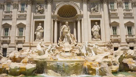 Trevi-District,-Rome,-Italy---The-Iconic-Trevi-Fountain,-Distinguished-by-its-Stunning-Baroque-Architecture---Pan-Down-Shot