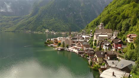 Aerial-view-of-Hallstatt,-Austria,-captured-by-drone,-showcasing-its-picturesque-lakeside-homes,-majestic-mountains,-and-the-unique-charm-of-this-enchanting-alpine-village