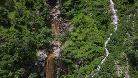 Drone-shot-captures-Nepal’s-waterfall-and-river-flooding-amidst-the-dense-forests-of-Sindhupalchowk-Muddy-water-landslides-flows-violently-urgency-of-environmental-protection-and-nature's-wrath