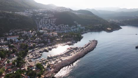 Luftaufnahme-Der-Marina-Von-Kas-In-Antalya,-Türkei,-Mit-Im-Hafen-Angedockten-Booten-Und-Wunderschönem,-Klarem-Wasser,-Das-In-Der-Sonne-Des-Mittelmeers-Glitzert