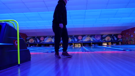 A-bowler-releasing-the-ball-down-a-neon-lit-lane-in-a-vibrant-bowling-alley