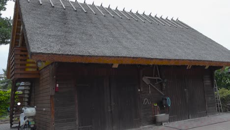 Old-traditional-wooden-house-or-a-building-in-Saaremaa-that-has-a-straw-or-a-rye-roof-with-a-balcony-during-summer-time