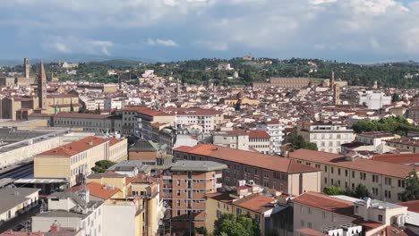 Aerial-rising-over-Florence,-Italy,-horizon-of-terracotta-rooftops-and-green-hills