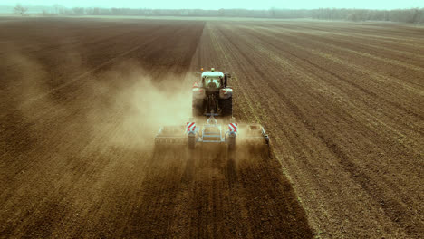 Tractor-handles-expansive-dry-land,-aerial-shot