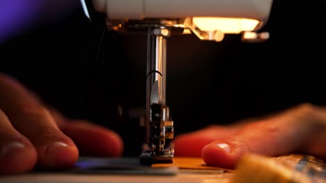 Front-view-of-a-sewing-machine-working-in-slow-motion-as-a-person-holds-the-fabric-in-place