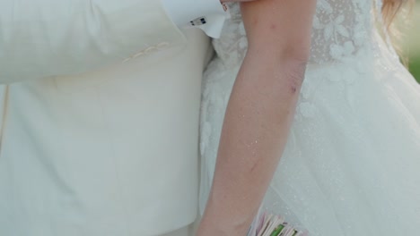 close-up-of-a-groom's-hand-holding-the-bride’s-arm,-highlighting-affection-and-the-bond-of-marriage