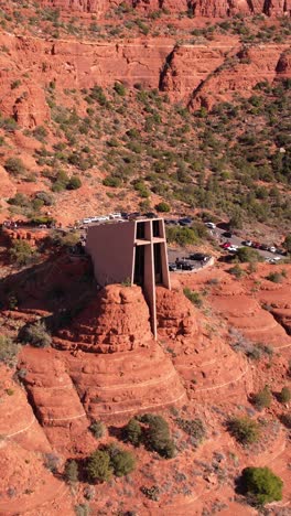 Vertical-Drone-Shot,-Chapel-of-Holy-Cross-Landmark-of-Sedona-Arizona-USA-in-Desert-Landscape