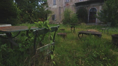 Old-Garden-With-Broken-Abandoned-Chairs-And-Benches---Panning-Shot