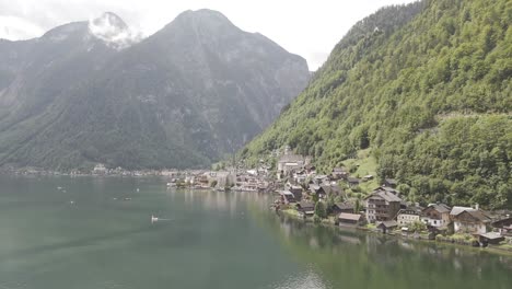 Aerial-view-of-Hallstatt,-Austria,-captured-by-drone,-showcasing-its-picturesque-lakeside-homes,-majestic-mountains,-and-the-unique-charm-of-this-enchanting-alpine-village