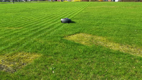 obotic-lawnmower-moving-across-large-green-field-with-striped-grass