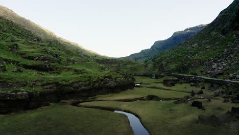 Drone-shot-of-a-river-feeding-into-a-lake-in-Ireland's-mountain-region