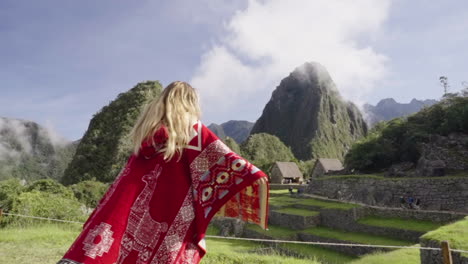 Happy-tourist-woman-with-peruvian-poncho-spinning-in-Machu-Picchu