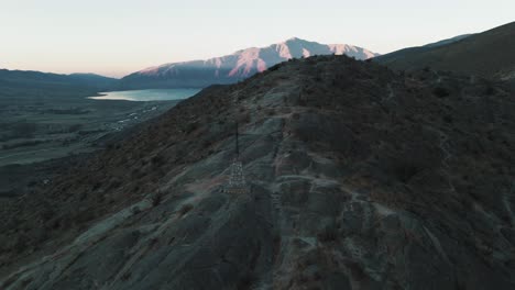 Drone-panoramic-view-of-the-silhouette-of-a-cross-on-top-of-a-hill