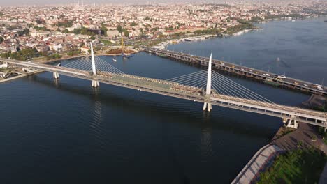 Drone-Flies-Above-Golden-Horn-Metro-Bridge-at-Sunrise-in-Istanbul,-Turkey