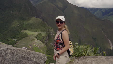 Touristin-Auf-Dem-Gipfel-Des-Berges-Huayna-Picchu,-Mit-Machu-Pichu-Im-Hintergrund