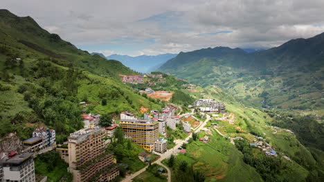 Sapa-town-hillside-hotels-and-resort-buildings,-Ha-Giang-Loop-route,-Drone-shot