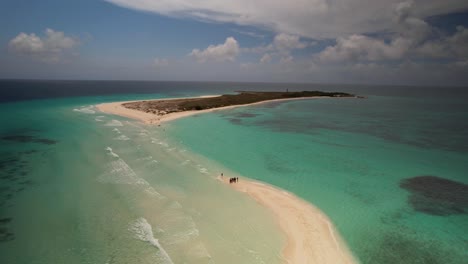 Aerial-view-zoom-out-group-people-enjoy-day-beach-sandbar,-Los-Roques-Venezuela