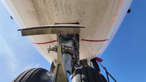 Extreme-low-angle-view-of-the-nose-wheels-of-a-jet-tilting-up