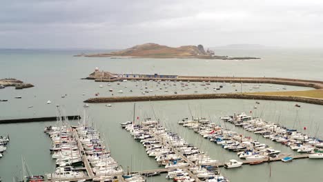 Vista-Aérea-De-Un-Dron-Sobre-Barcos-Atracados-En-El-Puerto-Con-El-Ojo-De-Irlanda-De-Fondo