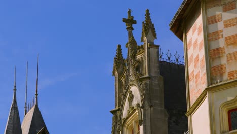 Camera-Pan-Revealing-Roof-of-Old-Historic-Château-with-Christian-Cross-and-Turret-in-Saumur,-France-4K