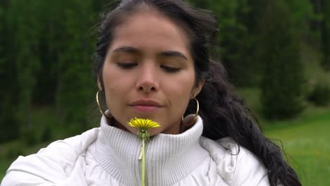 Happy-woman-with-deep-eyes-holding-yellow-dandelion,-portrait-view