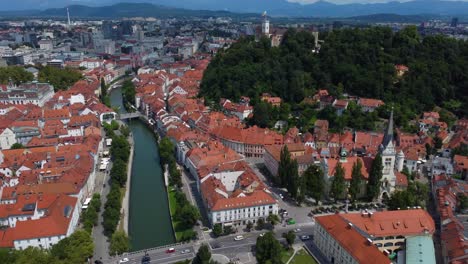 Cinematic-drone-aerial-view-of-Ljubljana-Old-Town-and-Ljubljana-Castle-with-mountains-in-the-background