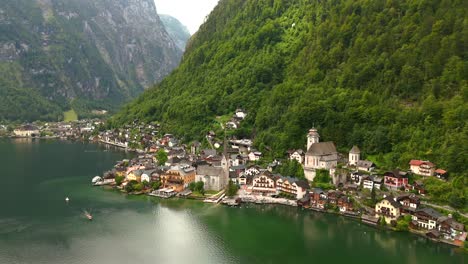 Aerial-view-of-Hallstatt,-Austria,-captured-by-drone,-showcasing-its-picturesque-lakeside-homes,-majestic-mountains,-and-the-unique-charm-of-this-enchanting-alpine-village