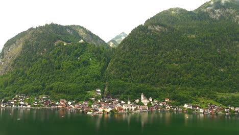 Aerial-view-of-Hallstatt,-Austria,-captured-by-drone,-showcasing-its-picturesque-lakeside-homes,-majestic-mountains,-and-the-unique-charm-of-this-enchanting-alpine-village