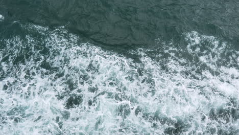 An-overhead-view-of-sparkling-turquoise-water,-showcasing-the-waves-created-by-movement