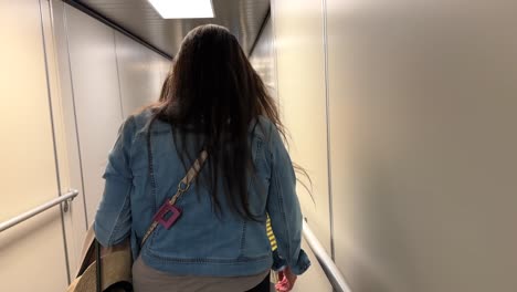 Female-Walking-Down-A-Airport-Jetway-To-A-Departing-Airplane,-Slow-Motion-Shot