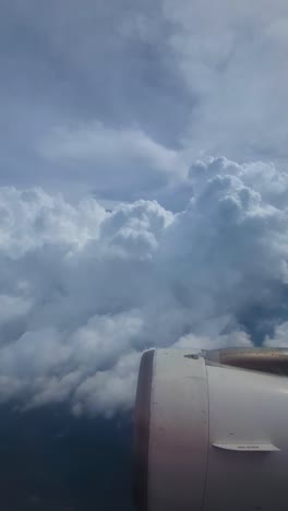 Vertical-View,-Airplane-Flying-Above-Rainy-Clouds,-Passenger-POV-Over-Engine