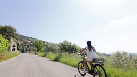 Italian-adult-female-bicycling-through-the-Tuscany,-Italy-countryside-on-a-sunny-day