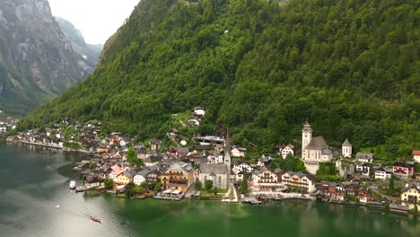 Aerial-view-of-Hallstatt,-Austria,-captured-by-drone,-showcasing-its-picturesque-lakeside-homes,-majestic-mountains,-and-the-unique-charm-of-this-enchanting-alpine-village