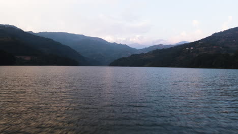 A-Serene-Vista-of-Phewa-Lake-Framed-by-the-Himalayan-Mountains-at-Sunset-in-Pokhara,-Nepal---Drone-Flying-Forward