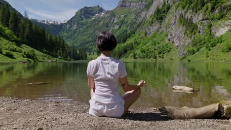 Woman-enjoying-peaceful-mountain-lake-surrounded-by-lush-greenery-and-scenic-alpine-landscape