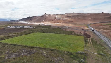 Panoramic-View-of-Hverarönd-Geothermal-Area-With-Green-Fields-and-Parked-Campers