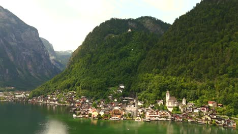 Aerial-view-of-Hallstatt,-Austria,-captured-by-drone,-showcasing-its-picturesque-lakeside-homes,-majestic-mountains,-and-the-unique-charm-of-this-enchanting-alpine-village