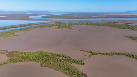 Aerial-flies-across-a-series-of-strange-wetland-landscapes-with-giant-pans-of-mud,-islands-of-mangrove,-and-languid-slow-waterways