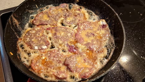 Hamburguesas-De-Carne-Fritas-En-Aceite-Caliente-En-La-Estufa-Con-Bordes-Burbujeantes-Y-Acabado-Dorado