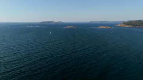 Aerial-view-of-open-sea-with-small-boats-and-distant-islands-in-the-background