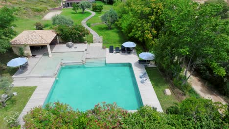 Slow-establishing-shot-of-a-tropical-swimming-pool-with-a-villa-in-France