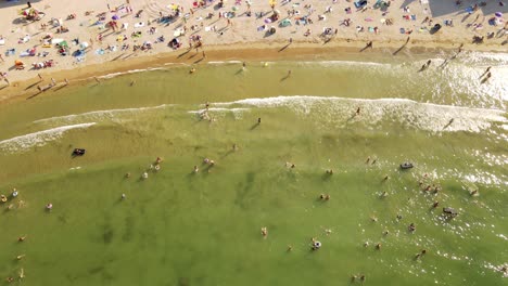 4k-cinematic-drone-stock-footage-of-people-having-fun-at-the-beach-on-a-sunny-and-hot-day