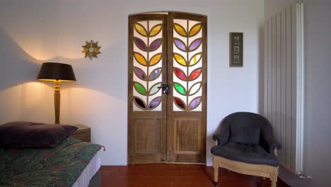 Slow-establishing-shot-of-a-bedroom-with-stained-glass-doors-opening