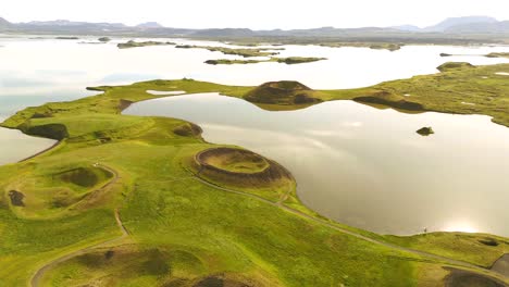 Discover-the-stunning-contrasts-of-green-and-black-at-Skútustaðagígar,-as-the-drone-captures-the-intricate-details-of-this-unique-geological-wonder