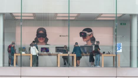 Customers-shop-for-Apple-products-at-the-American-tech-company's-store,-while-a-poster-showcasing-the-Apple-Vision-Pro,-Apple's-new-mixed-reality-headset,-is-visible-in-the-background-in-China