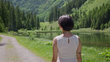 Eine-Frau-Mit-Kurzen-Haaren-Steht-An-Einem-Ruhigen-See,-Umgeben-Von-üppigen-Bergen-In-Talalpsee-Filzbach