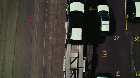 Aerial-top-view-over-a-car-carrier-trailer,-car-hauler-truck,-loading-cars