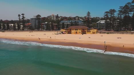 Aerial-pullback-shot-of-surf-club-on-Manly-beach,-Sydney,-Australia