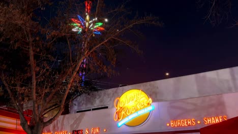 Tilt-up-of-a-Johnny-Rockets-themed-restaurant,-hamburger-restaurant-at-night,-high-chairs-with-lights,-Fantasilandia-amusement-park,-Santiago-de-Chile