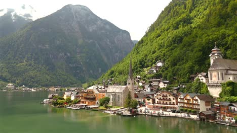 Aerial-view-of-Hallstatt,-Austria,-captured-by-drone,-showcasing-its-picturesque-lakeside-homes,-majestic-mountains,-and-the-unique-charm-of-this-enchanting-alpine-village